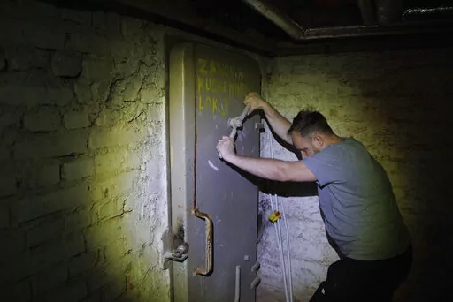 Jacek, 37, a local resident, closes a door to a shelter in the basement of a residential building in Warsaw, Poland, Wednesday, Oct. 19, 2022. Fighting around Ukraine's nuclear power plants and Russia's threats to use nuclear weapons have reawakened nuclear fears in Europe. This is especially felt in countries near Ukraine, like Poland, where the government this month ordered an inventory of the country's shelters as a precaution. (AP Photo/Michal Dyjuk)