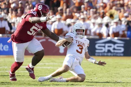 Texas quarterback Quinn Ewers (3) slides to the ground after a gain of yards as Oklahoma defensive lineman Damonic Williams (52) pressures in the second half of an NCAA college football game in Dallas, Saturday, Oct. 12, 2024. (AP Photo/Jeffrey McWhorter)