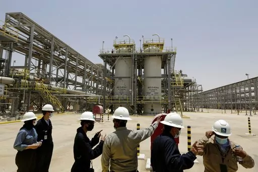 Saudi Aramco engineers and journalists look at the Hawiyah Natural Gas Liquids Recovery Plant in Hawiyah, in the Eastern Province of Saudi Arabia on June 28, 2021. Saudi oil company Aramco’s half-year profits peaked just shy of $88 billion for the first half of the year as oil prices remain high globally. The oil and gas company, which is nearly entirely state-owned, said Sunday, Aug. 14, 2022, it also saw a 90% surge in net profits for the second quarter of 2022 compared to the same time last