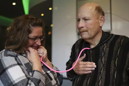 Amber Morgan, from South Bend, Ind., listens to the heartbeat of Tom Johnson, from Kankakee, at Travelodge by Wyndham Downtown Chicago, on Saturday, Nov. 19, 2022, in Chicago. Morgan and Johnson met for the first time Saturday, four years after he received a heart transplanted from the body of Morgan's daughter, Andreona Williams, who was 20 when she died from asthma complications. “It’s almost like I got to hug my daughter again,” Morgan said. (Michael Blackshire/Chicago Tribune via AP)
