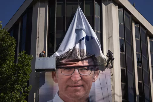 Workers remove an electoral poster showing Alberto Feijoo, leader of the mainstream conservative Popular Party, at the party headquarters in Madrid, Spain, Monday, July 24, 2023. Spaniards woke up Monday to find their country in political disarray after elections a day earlier left no party with a clear path to forming a government. (AP Photo/Emilio Morenatti)