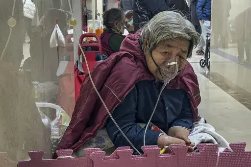 An elderly patient receives an intravenous drip while using a ventilator in the hallway of the emergency ward in Beijing, Thursday, Jan. 5, 2023. (AP Photo/Andy Wong, File)