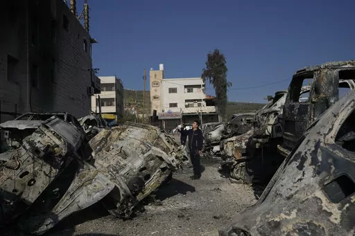 Palestinians take photos of burned cars in the town of Huwara, near the West Bank city of Nablus, Monday, Feb. 27, 2023. Scores of Israeli settlers went on a violent rampage in the northern West Bank, setting cars and homes on fire after two settlers were killed by a Palestinian gunman. Palestinian officials say one man was killed and four others were badly wounded. (AP Photo/Majdi Mohammed)