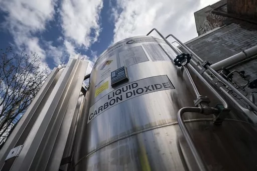 A liquid carbon dioxide containment unit stands outside the fabrication building of Glenwood Mason Supply Company, April 18, 2023, in the Brooklyn borough of New York. The Biden administration announced on Wednesday, May 17, $251 million for carbon capture and storage projects in seven states. (AP Photo/John Minchillo, File)