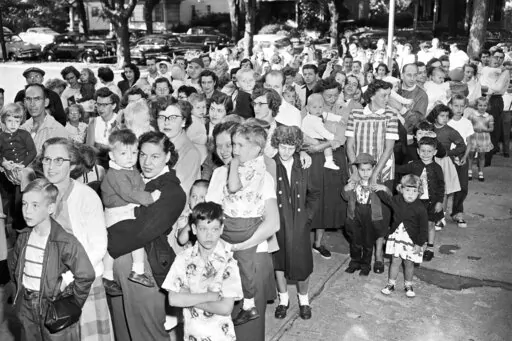 Parents and children wait outside the Riverside Public School in Elmira, N.Y., on July 1, 1953, to get the polio vaccine, due to the rise in infantile paralysis in Chemung and Steuben Counties. The Centers for Disease Control and Prevention said the polio virus was detected in wastewater samples collected in June 2022 from Rockland County outside New York City. An unvaccinated adult recently contracted the life-threatening disease, but health officials said Tuesday, Aug. 2, 2022, they have not i