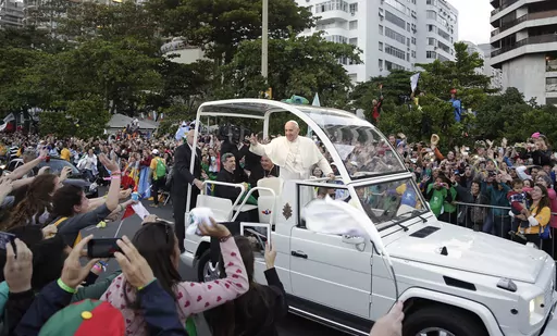Pope Francis waves to people from his popemobile along the Copacabana beachfront as he arrives for the Stations of the Cross procession in Rio de Janeiro, Brazil, Friday, July 26, 2013. When Pope Francis made the first foreign trip of his papacy, to Rio de Janeiro for World Youth Day in 2013, he urged young people to make a "mess" in their local churches, to shake things up even if it ruffled the feathers of their bishops. (AP Photo/Andre Penner, File)