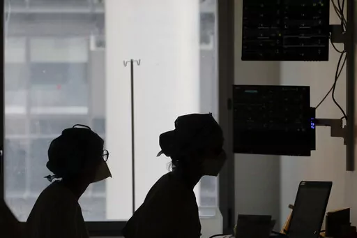 Nurses look at a screen near rooms with patients suffering from COVID-19, in the ICU unit at the Charles Nicolle public hospital, in Rouen, France, April 15, 2021. France is rolling out a new rule that will allow health workers who are infected with the coronavirus but have few or no symptoms to keep treating patients rather than self-isolate. The extraordinary stop-gap measure is an attempt to address staff shortages at hospitals caused by an unprecedented explosion in virus infections. (AP Pho