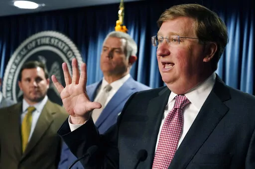 House Speaker Philip Gunn, R-Clinton, center, listens as Republican Gov. Tate Reeves, speaks about signing a bill that will reduce the state income tax over four years, beginning in 2023, at his office in Jackson, Miss., Tuesday, April 5, 2022. (AP Photo/Rogelio V. Solis)