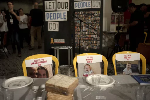 Chairs for the Bibas family, hostages held in Gaza, are seen at a Passover seder table set, Thursday, April 11, 2024, at the communal dining hall at Kibbutz Nir Oz in southern Israel, where a quarter of all residents were killed or captured by Hamas on Oct. 7, 2023. Passover is a major Jewish holiday, celebrated over seven or eight days each year, commemorating the exodus of ancient Israelites from slavery in Egypt, as recounted in the Bible. To many Jews, it symbolizes freedom and the birth of 