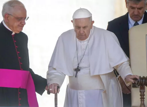 Pope Francis is helped by his aide Monsignor Leonardo Sapienza, left, as he walks with a cane to his weekly general audience in St. Peter's Square at The Vatican, on June 1, 2022. Pope Francis has revealed in an interview published Sunday Dec. 18, 2022 that shortly after being elected pontiff in 2013 he wrote a resignation letter in case medical problems impede him from carrying out duties. (AP Photo/Gregorio Borgia, File)