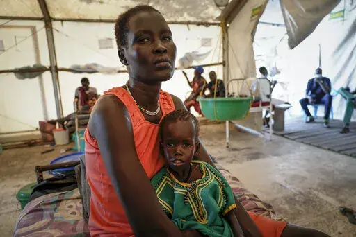 Nyayiar Kuol holds her severely malnourished 1-year-old daughter Chuoder Wal in a hospital run by Medicines Sans Frontieres (Doctors Without Borders) in Old Fangak in Jonglei state, South Sudan Tuesday, Dec. 28, 2021. Aid groups say more people than ever in the country will face hunger this year, because of the worst floods in 60 years as well as conflict and the sluggish implementation of the peace agreement that has denied much of the country basic services. (AP Photo/Sam Mednick)