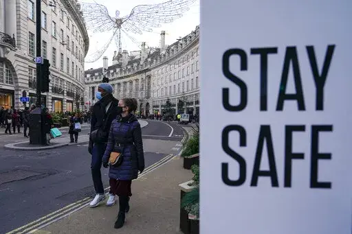 People wear face masks as they walk, in Regent Street, in London, Sunday, Nov. 28, 2021. The number of new coronavirus cases across Britain has surged by more than 30% in the last week, with cases largely driven by the super infectious omicron variants. Data released by Britain’s Office for National Statistics on Friday, July 1, 2022 showed that more than 3 million people in the U.K. had COVID-19 last week, although there has not been an equivalent spike in hospitalizations. (AP Photo/Alberto 