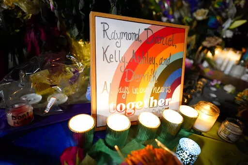 Names of the victims are shown on a rainbow during a candlelight vigil on a corner near the site of a weekend mass shooting at a gay bar, late Monday, Nov. 21, 2022, in Colorado Springs, Colo. (AP Photo/Jack Dempsey)
