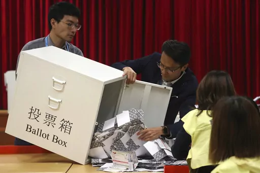 Election workers empty a ballot box to count votes for a district council election at a polling station in Hong Kong, Nov. 24, 2019. Hong Kong's leader on Tuesday, May 2, 2023, stepped up a campaign to shut down democratic challenges by unveiling plans to eliminate most directly elected seats on local district councils, the last major political representative bodies mostly chosen by the public. (AP Photo/Ng Han Guan, File)