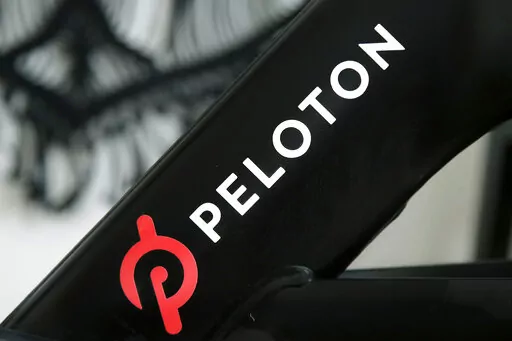 A Peloton logo is seen on the company's stationary bicycle on Nov. 19, 2019, in San Francisco. Peloton is laying off employees and raising prices for some of its equipment as part of its latest bid to make the business profitable and free up cash, according to a memo disclosed to employees on Friday, Aug. 12, 2022. (AP Photo/Jeff Chiu, File)