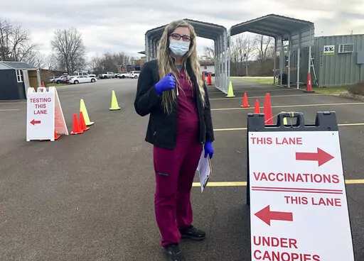 Roane General Hospital nurse Chania Batten is shown at a drive-thru COVID-19 vaccination clinic Tuesday, Dec. 21, 2021, in Spencer, W.Va. Batten says her job at times is overwhelming administering COVID-19 vaccines at the clinic at the only hospital in rural Roane County. She's spent months patiently answering questions, dispelling misinformation and reassuring the skeptical that the shots are the key to beating back the virus. (AP Photo/John Raby)