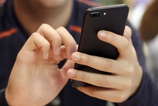 A person uses a smartphone in Chicago, Sept. 16, 2017. Most Democrats and Republicans agree that the federal government should better regulate the biggest technology companies, particularly social media platforms. But there is very little consensus on how it should be done. (AP Photo, File)