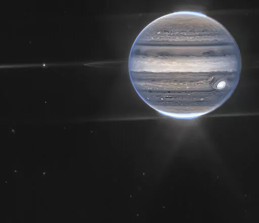 This image provided by NASA shows a false color composite image of Jupiter obtained by the James Webb Space Telescope on July 27, 2022. The planet’s rings and some of its small satellites are visible along with background galaxies. (NASA via AP)