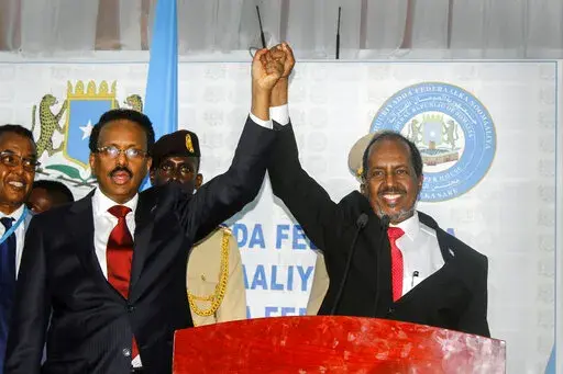 Hassan Sheikh Mohamud, right, marks his election win with incumbent leader Mohamed Abdullahi Mohamed, left, at the Halane military camp in Mogadishu, Somalia, Sunday, May 15, 2022. Former President Mohamud, who was voted out of power in 2017, has been returned to the nation's top office after defeating the incumbent leader in a protracted contest decided by legislators in a third round of voting late Sunday. (AP Photo/Farah Abdi Warsameh)