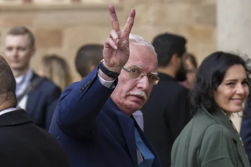 Palestinian Foreign Minister Riad al-Malki flashes a victory sign in Barcelona, Spain, Monday, Nov. 27, 2023. Delegations from the European Union member states and from Middle East and northern Africa countries are meeting Monday in Barcelona, Spain, to discuss the crisis in Gaza where a fragile pause in fighting is set to expire. Forty-two delegations will gather at the Union for the Mediterranean event with many represented by their foreign ministers. Israel is not attending. (AP Photo/Emilio 