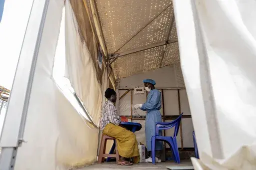 A health worker attends to a mpox patient, at a treatment centre in Munigi, eastern Congo, Monday, Aug. 19, 2024. (AP Photo/Moses Sawasawa, File)