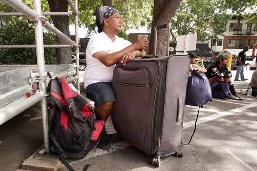 Eric Santos uses a suitcase that he keeps all of his possessions in as a table while having a cup of coffee at ShowUp Sac, a nonprofit that provides food, clothing and showers to people experiencing homelessness in Sacramento, Calif., Tuesday, Aug. 9, 2022. Santos, who was recently evicted from his apartment and now sleeps on a park bench, frequents Show Up Sac, for meals and other assistance. Sacramento County had more than 9,200 people experiencing homelessness during this year's annual count,