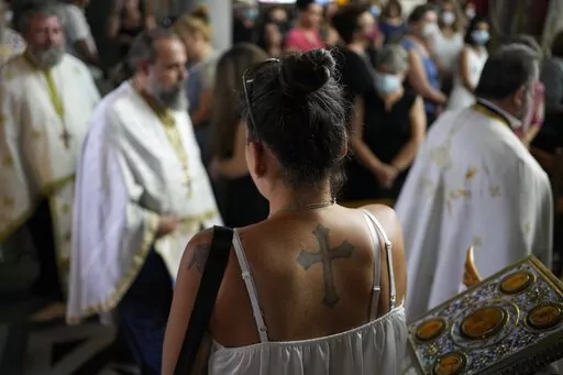 A pilgrim attends a church service at a Greek Orthodox temple in Hasia, northwestern Athens, Greece, Sunday, Aug. 14, 2022. The Dormition of the Virgin Mary (or Mother of God as the Greeks usually refer to her) is celebrated on Aug. 15. The religious event is coupled with midsummer festivities, known as Panigiria, that often last more than a day with music, culinary feasts and, in many cases, flea markets. (AP Photo/Thanassis Stavrakis)