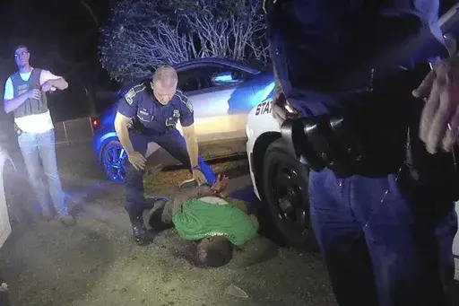 FILE — This image from video from Louisiana state trooper Lt. John Clary's body-worn camera shows trooper Kory York standing over Ronald Greene on his stomach on May 10, 2019, outside of Monroe, La. (Lt. John Clary/Louisiana State Police via AP, File)