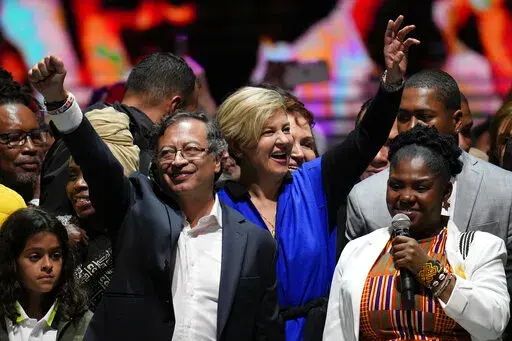 Former rebel Gustavo Petro, left, his wife Veronica Alcocer, back center, and his running mate Francia Marquez, celebrate before supporters after winning a runoff presidential election in Bogota, Colombia, Sunday, June 19, 2022. (AP Photo/Fernando Vergara)
