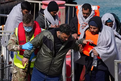 A group of people thought to be migrants are brought in to Dover, Kent, by the RNLI, following a small boat incident in the Channel, Thursday April 14, 2022. Britain's Conservative government has struck a deal with Rwanda to send some asylum-seekers thousands of miles away to the East African country, a move that opposition politicians and refugee groups condemned as inhumane, unworkable and a waste of public money. (Gareth Fuller/PA via AP)