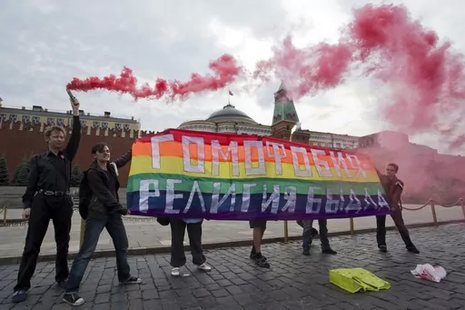Gay rights activists hold a banner reading "Homophobia - the religion of bullies" during their action in protest at homophobia, on Red Square in Moscow, Russia, on July 14, 2013. Russian lawmakers on Wednesday June 14, 2023 approved in first reading a bill outlawing gender-affirming medical care and changing gender in official documents in yet another crippling blow to Russia's already beleaguered LGBTQ+ community. (AP Photo/Evgeny Feldman, File)