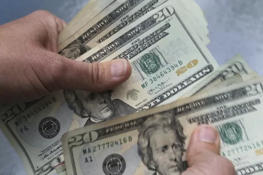 In this June 15, 2018 file photo, twenty dollar bills are counted in North Andover, Mass. Only one-third of men correctly estimated how long a 60-year-old man in the U.S. could expect to live, according to a 2022 TIAA Institute survey. And fewer than half of women got it right for a 60-year-old woman. (AP Photo/Elise Amendola, File)