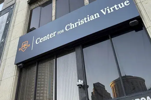 The Ohio Statehouse is reflected in a window of The Center for Christian Virtue in downtown Columbus, Ohio, on Monday, Nov. 11, 2024. (AP Photo/Julie Carr Smyth)
