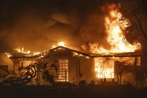 A house burns on Platina Road at the Zogg Fire near Ono, Calif., on Sept. 27, 2020. A Northern California judge on Wednesday, May 31, 2023, dismissed all charges against Pacific Gas & Electric for its role in the 2020 fatal wildfire sparked by its equipment that destroyed hundreds of homes and killed four people, including an 8-year-old child. (AP Photo/Ethan Swope, File)