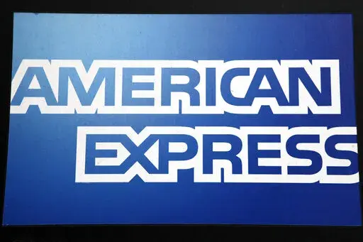 This Jan. 21, 2015, file photo, shows a sign for American Express outside a New York business. American Express launched its own checking account product on Tuesday, Feb. 8, 2022, a product that will allow its customers to accrue its popular Membership Rewards points the same way they do on its credit and charge cards.    (AP Photo/Mark Lennihan, File)