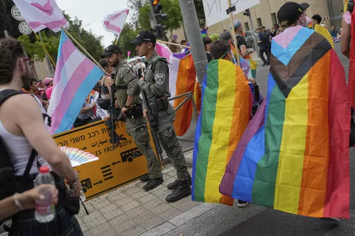 Israeli border police officers stand guard as participants march in the annual Pride parade in Jerusalem, Thursday, June 1, 2023. Thousands of people march in Jerusalem's Pride parade on Thursday, an annual event that is taking place this year under Israel's most right-wing government ever, stacked with openly homophobic members. (AP Photo/Ohad Zwigenberg)