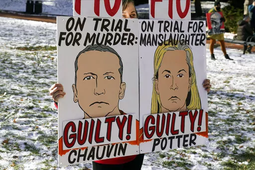 A demonstrator holds up "GUILTY" signs at the Hennepin County Government Center, Dec. 23, 2021, in Minneapolis, where jurors found former suburban Minneapolis police officer Kim Potter guilty of first degree and second degree manslaughter in the death of motorist Daunte Wright during a traffic stop. Data show it's rare for police officers to be convicted of on-duty killings. But three recent convictions of police officers in Minnesota have some people wondering whether that's changing. (AP Photo