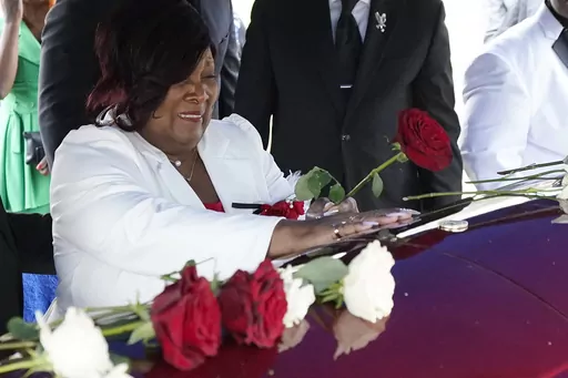 Bettersten Wade, mother of Dexter Wade, cries as she leaves a rose on her son's coffin in Jackson, Miss. Monday, Nov. 20, 2023. Dexter Wade, a 37-year-old man who died after being hit by a Jackson police SUV driven by an off-duty officer, was initially buried in a paupers cemetery without any notification to his family. (AP Photo/Rogelio V. Solis)