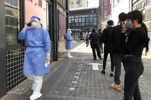 Residents line up for mass testing in a lockdown area in the Jingan district of western Shanghai, Monday, April 4, 2022. Shanghai allowed 4 million more people out of their homes Wednesday, April 20, 2022, as coronavirus rules that shut down China’s largest city eased and some factories resumed operation. (AP Photo/Chen Si, File)