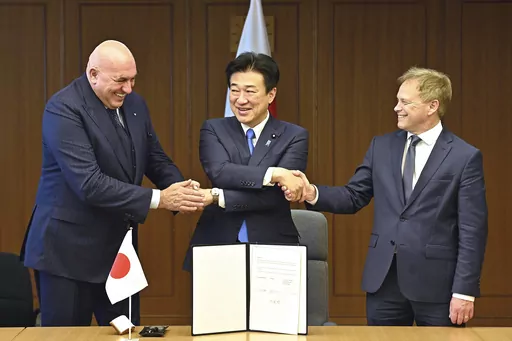 Britain's Defense Minister Grant Shapps, right, Italy's Defense Minister Guido Crosetto, left, and Japanese Defense Minister Minoru Kihara, center, shake hands after a signing ceremony for the Global Combat Air Programme (GCAP) at the defense ministry, Dec. 14, 2023, in Tokyo, Japan. Japan’s Cabinet on Tuesday, March 26, 2024, approved a plan to sell future next-generation fighter jets that it’s developing with Britain and Italy to other countries, in the latest move away from the country’