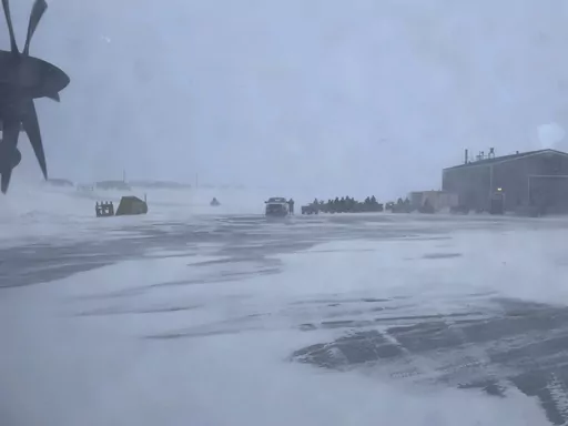This March 28, 2023, photo shows townspeople in Gambell, Alaska, waiting in a snowstorm on four-wheelers to transport Alaska National Guard personnel from the air strip to the school for a ceremony. Sixteen Alaska National Guard members were honored for helping rescue the 11 crew members of a Navy plane that was shot down in 1955 by Soviet jet fighters and crash-landed about 8 miles from Gambell, on St. Lawrence Island, and 15 medals were presented posthumously. (AP Photo/Mark Thiessen)