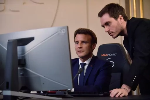 French President Emmanuel Macron plays a video game next to Adrien Nougaret, aka ZeratoR, during a meeting with French esport video game players at the Elysee Palace in Paris, Friday June 3, 2022. French President Emmanuel Macron is extending an olive branch to video gamers after previously linking video games to riots that rocked France this year. Posting on the platform previously known as Twitter, Macron backpedalled on remarks where he had blamed video games for having “intoxicated” some