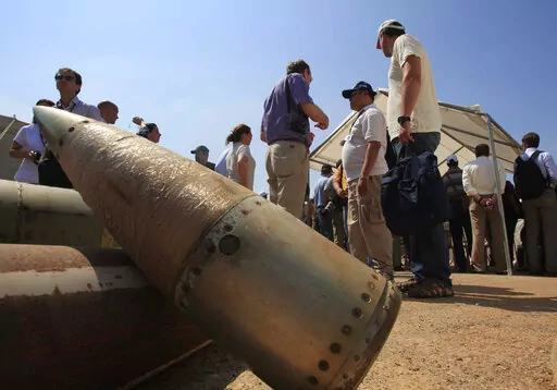 Activists and international delegations stand next to cluster bomb units, during a visit to a Lebanese military base at the opening of the Second Meeting of States Parties to the Convention on Cluster Munitions, in the southern town of Nabatiyeh, Lebanon, Monday Sept. 12, 2011.  Rights groups and observers say Russia is using cluster bombs in its invasion of Ukraine, a charge Moscow denies. If confirmed, deployment of the weapon, especially in crowded civilian areas, would usher in new humanitar
