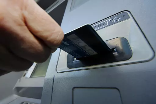 In this Saturday, Jan. 5, 2013 file photo, a person inserts a debit card into an ATM in Pittsburgh. Now is a great time to look for a bank or credit union that aligns with your values. Whether you care about fighting climate change or supporting community development and racial equity, there are financial institutions that want to use your money to create a more sustainable and fair world. (AP Photo/Gene J. Puskar, File)