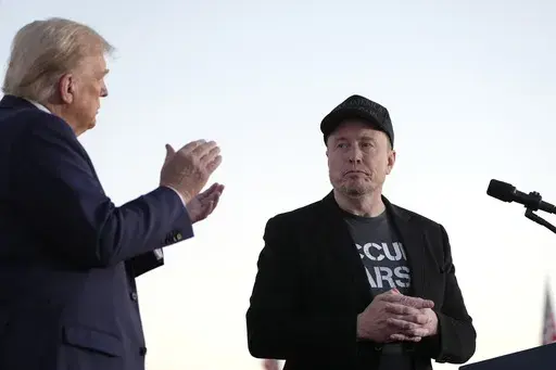 Republican presidential nominee former President Donald Trump, left, claps as Tesla and SpaceX CEO Elon Musk prepares to depart after speaking at a campaign event at the Butler Farm Show, on Oct. 5, 2024, in Butler, Pa. (AP Photo/Alex Brandon, File)