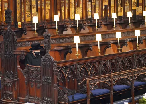 Britain's Queen Elizabeth II sits alone in St. George's Chapel during the funeral of Prince Philip, the man who had been by her side for 73 years, at Windsor Castle, Windsor, England, Saturday April 17, 2021. In retrospect, it seems Queen Elizabeth II was preparing us all along for her death. Whether it was due to age, ill health or a sense that the end was near, she spent much of the last two years tying up loose ends, making sure the family firm would keep ticking along. (Jonathan Brady/Pool v