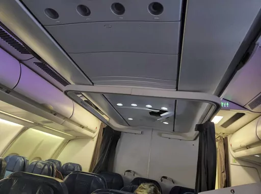 This photo provided by Tara Goodall shows a crack in the ceiling of a Hawaiian Airlines plane that encountered severe turbulence during a flight from Honolulu to Sydney, June 30, 2023. The airline says airport medics assessed and released three injured passengers when the flight landed in Sydney. One passenger and three flight attendants were "referred for further evaluation," the airline said. (Tara Goodall via AP)
