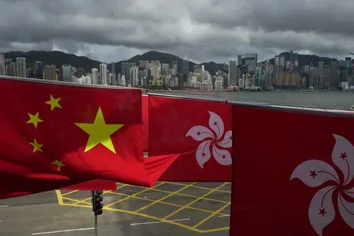 Chinese and Hong Kong flags are hanged to celebrate the 25th anniversary of Hong Kong handover to China, in Hong Kong, Friday, June 17, 2022. Hong Kong is preparing to introduce new middle school textbooks that will deny the Chinese territory was ever a British colony. (AP Photo/Kin Cheung)