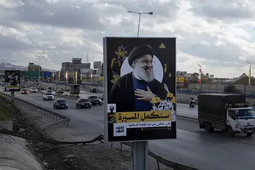 People drive past a billboard with a picture of the late Lebanon's Hezbollah leader Sayyed Hassan Nasrallah displayed on Beirut airport highway, Lebanon, Friday, Feb. 21, 2025. (AP Photo/Bilal Hussein)