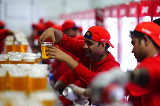 Staff member holds a beer at a fan zone ahead of the FIFA World Cup, in Doha, Qatar Saturday, Nov. 19, 2022. (AP Photo/Petr Josek, File)